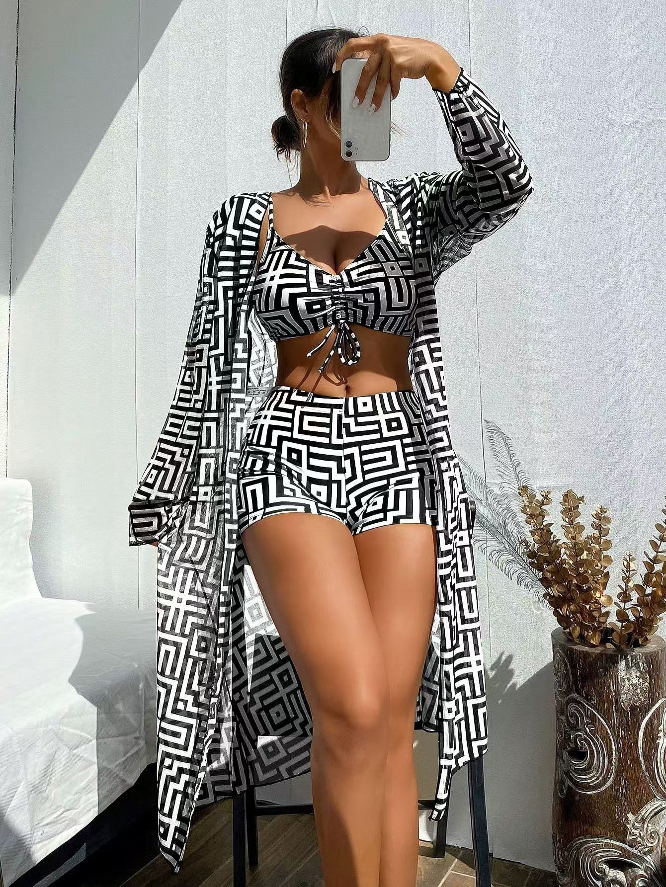 Conjunto de tres piezas para mujer compuesto por un bañador rectangular estampado de dos piezas y una prenda para cubrirse